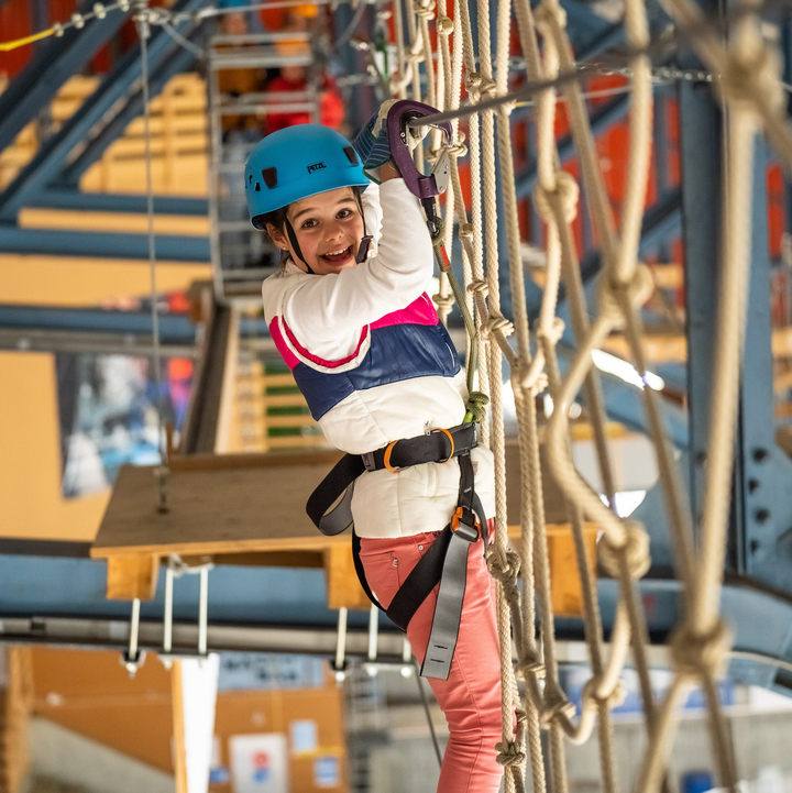 Indoor-Ropes-Park_009_Switzerland.jpg A young girl stands on a rope ladder and grabs the safety cable as she navigates a course at the Indoor Ropes Park in Grindelwald